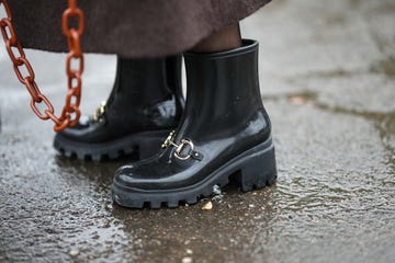 copenhagen, denmark january 31 a guest wears a dark brown fluffy long coat, a camel shiny leather handbag, black tights, black shiny varnished plastic rain ankle boots, outside aeron , during the copenhagen fashion week autumnwinter 2023 on january 31, 2023 in copenhagen, denmark photo by edward berthelotgetty images