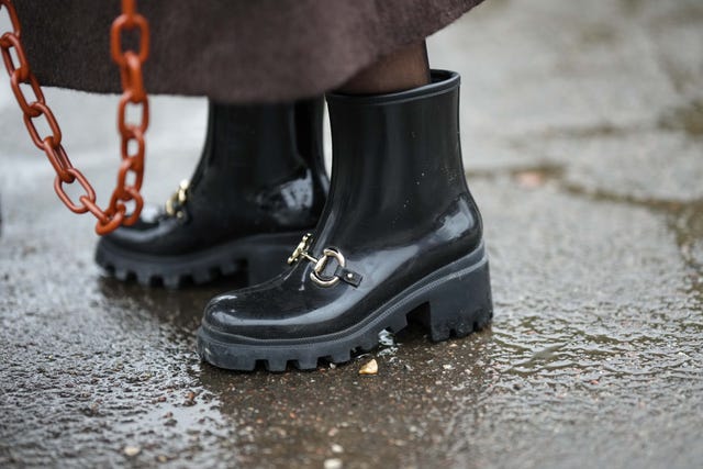 copenhagen, denmark january 31 a guest wears a dark brown fluffy long coat, a camel shiny leather handbag, black tights, black shiny varnished plastic rain ankle boots, outside aeron , during the copenhagen fashion week autumnwinter 2023 on january 31, 2023 in copenhagen, denmark photo by edward berthelotgetty images