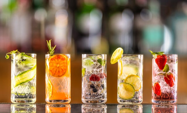 five gin tonic cocktails in wine glasses on bar counter in pup or restaurant