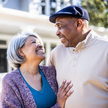 Portrait of senior couple in front of suburban home love message texts