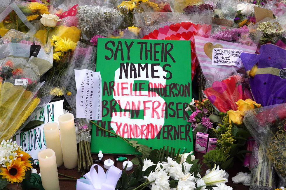 flowers and a sign that reads say their names