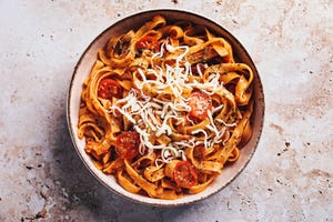 flat lay of tagliatelle with tomato sauce on stone texture background