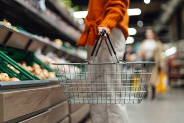 lower section of young woman standing next to product aisle and choosing vegetables in the store young asian woman doing grocery shopping in supermarket