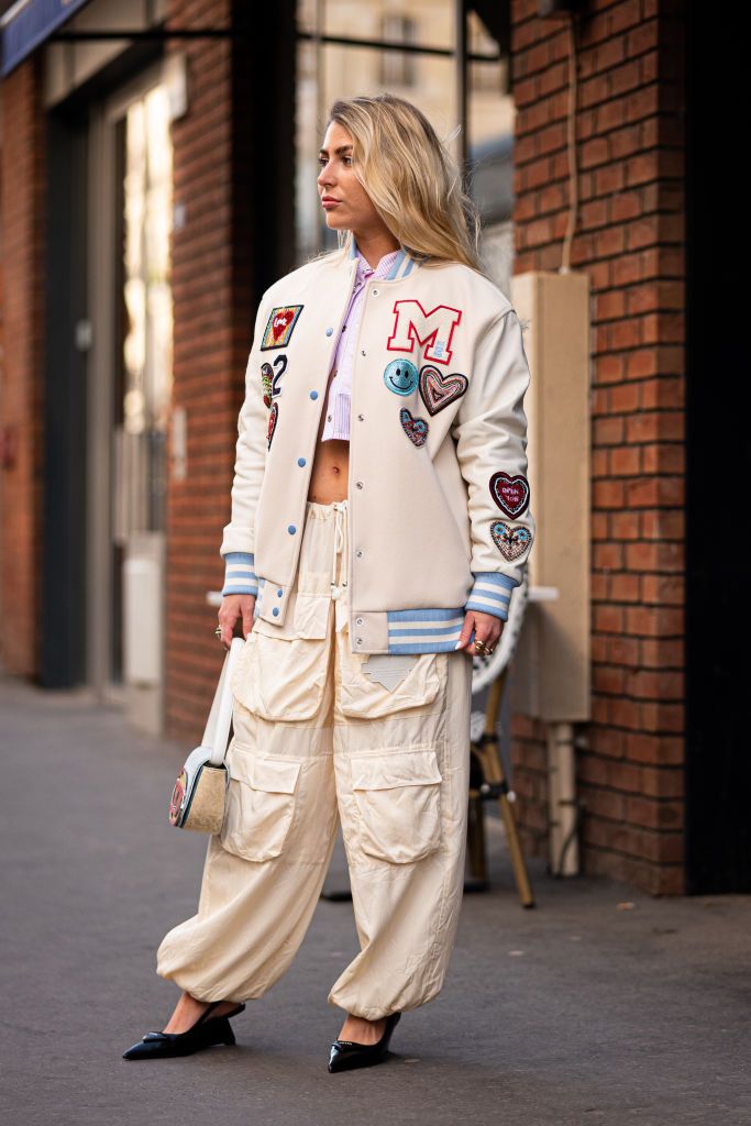 paris, france february 28 emma bonneaud wears a cream decorated bomber jacket, parachute cream pants, pink striped cropped shirt and diesel bag, outside victoriatomas, during paris fashion week womenswear fall winter 2023 2024, on february 28, 2023 in paris, france photo by claudio laveniagetty images