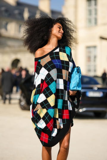 paris, france march 03 a guest wears a black red beige blue white jacquard print pattern wool shoulder off oversized pullover dress, a flashy blue shiny leather handbag , outside loewe, during paris fashion week womenswear fall winter 2023 2024, on march 03, 2023 in paris, france photo by edward berthelotgetty images