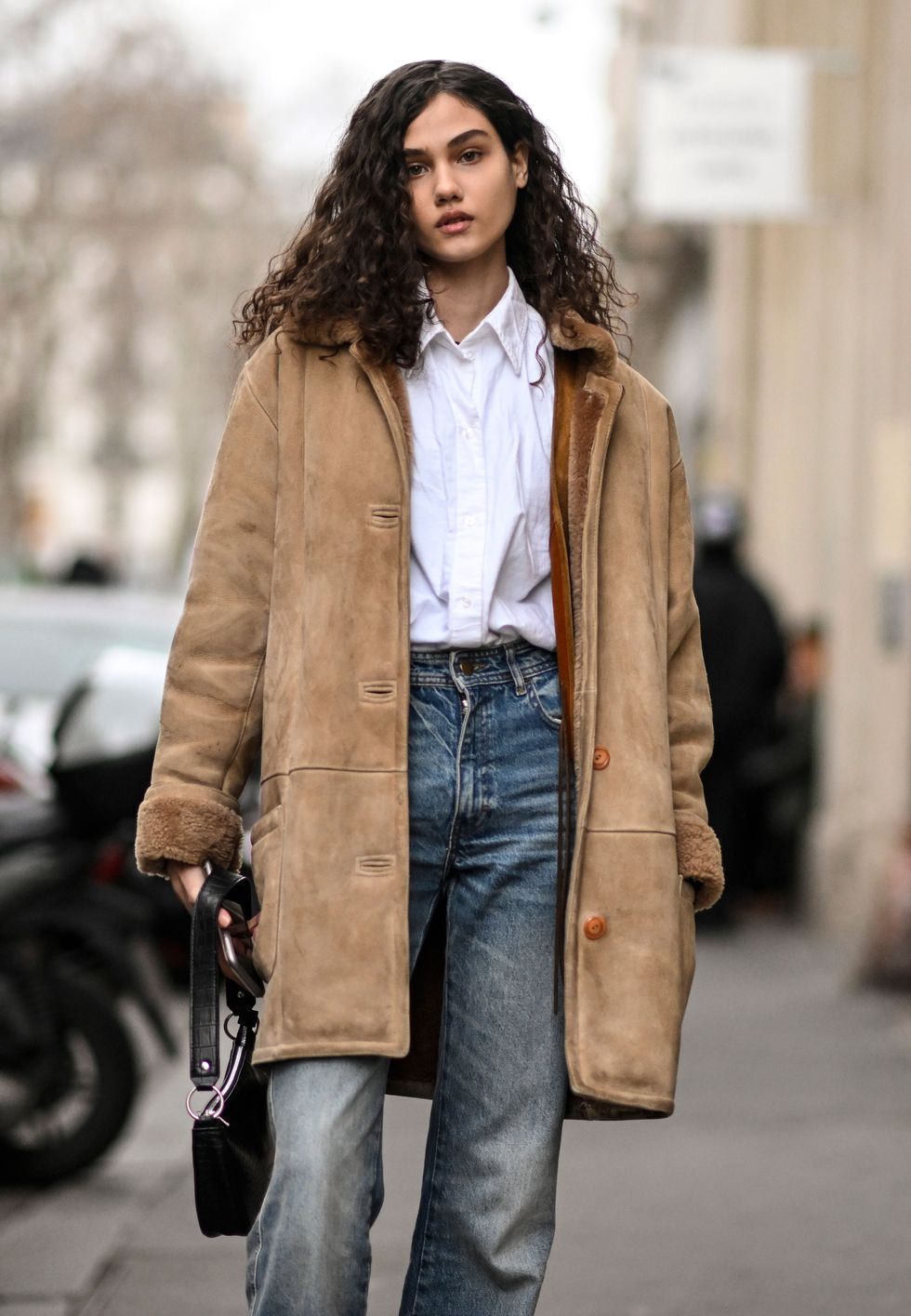 woman wearing suede jacket white button down and jeans