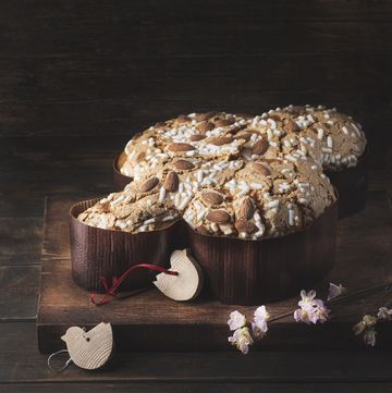 Сolomba pasquale italian sweet easter bread or cake with almonds and powdered sugar and candied fruits the baked dove is a symbol of christ and the easter holiday rustic wooden background, copy space