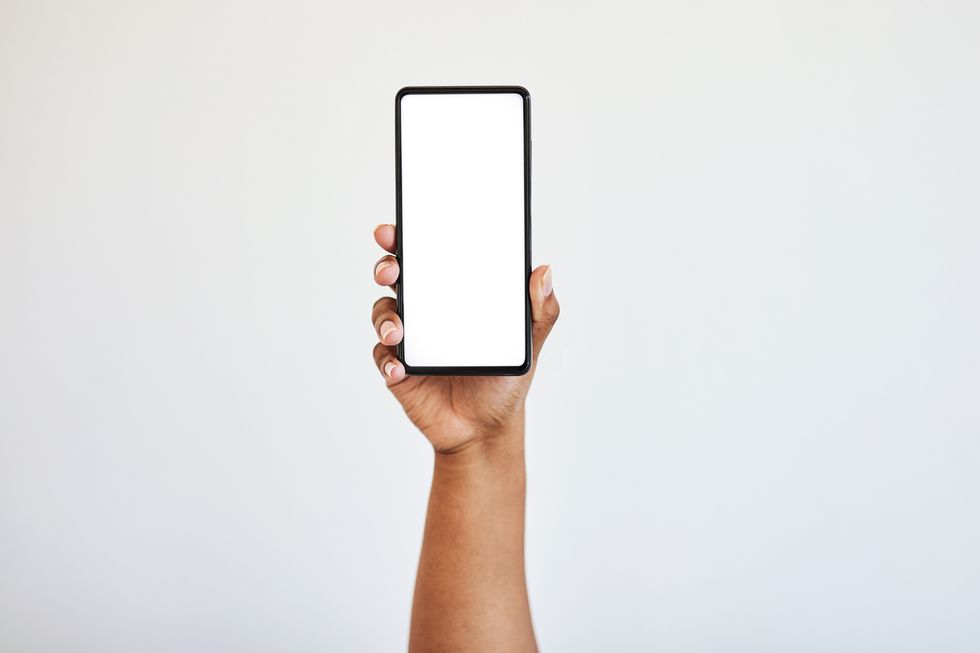 hand holding phone, blank screen with mockup and black woman hands in studio isolated on white background technology, connect and zoom on space on smartphone for website, social media or advertising