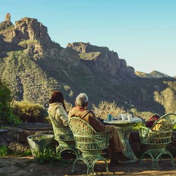 mature couple having breakfast in the garden of a rural hotel with a spectacular landscape