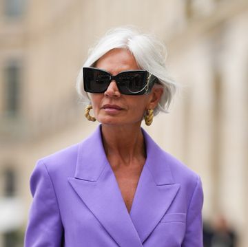 paris, france april 26 grece ghanem wears black sunglasses from saint laurent, a beige leather and gold braided earrings, a purple oversized blazer jacket, matching purple large suit pants, a dark brown shiny braided leather handbag, outside the cos show, on april 26, 2023 in paris, france photo by edward berthelotgetty images