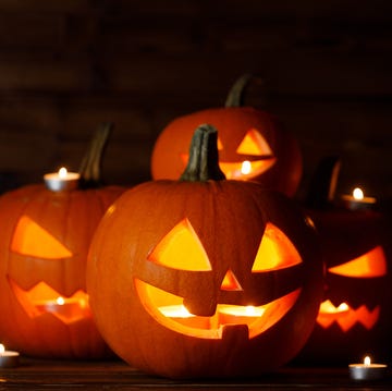 pumpkin carving, Close-up of pumpkins on table pumpkin carving, group of glowing halloween pumpkin lanterns and burning candles on dark wooden background