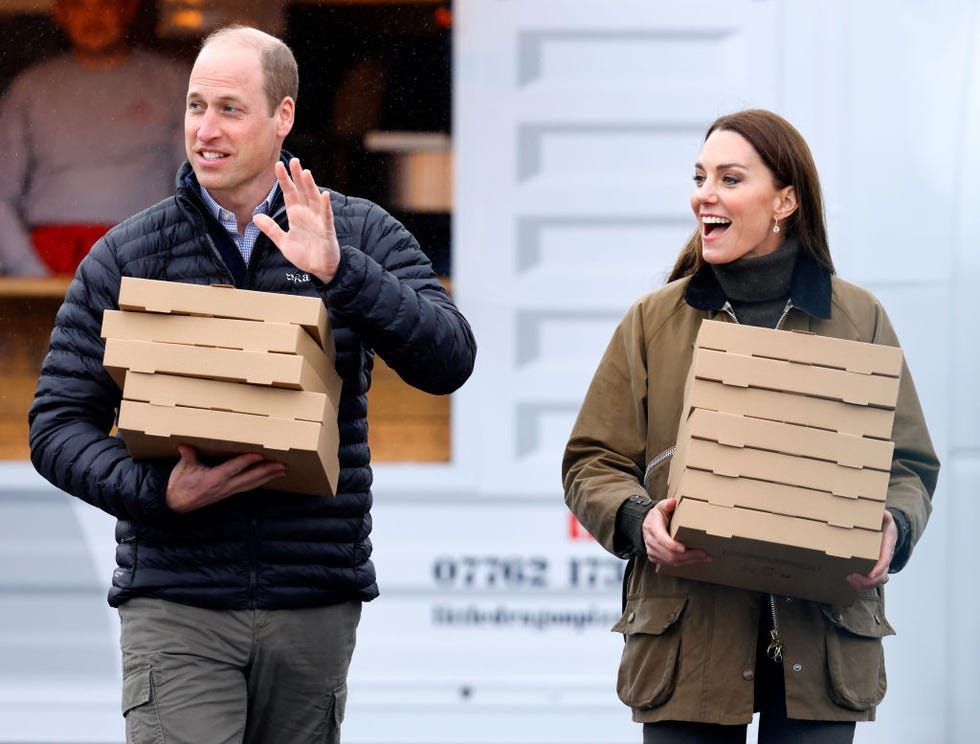 merthyr tydfil, united kingdom april 27: (embargoed for publication in uk newspapers until 24 hours after create date and time) prince william, prince of wales and catherine, princes of wales carry takeaway pizza boxes, collected from a pizza van, as they visit dowlais rugby club on april 27, 2023 in merthyr tydfil, wales. the prince and princes of wales are visiting the country to celebrate the 60th anniversary of central beacons mountain rescue and to meet members of local communities. (photo by max mumby/indigo/getty images)
