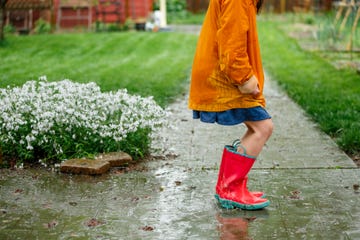 farmers almanac 2025 spring predictions bottom half of child in rain boots splashing in puddle