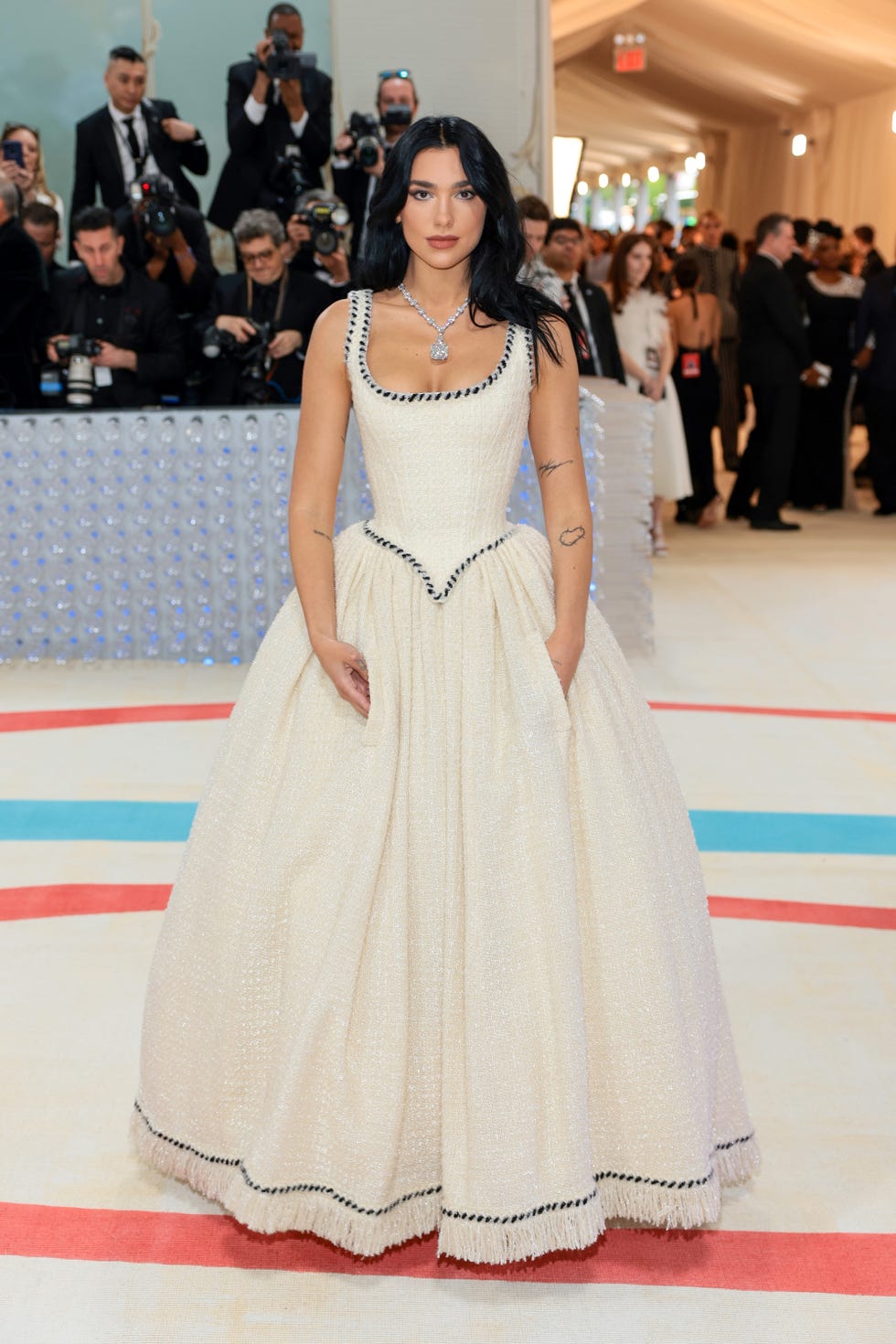 Dua Lipa Carries a Feathered Cape Over a Lace Set at the 2024 Met Gala