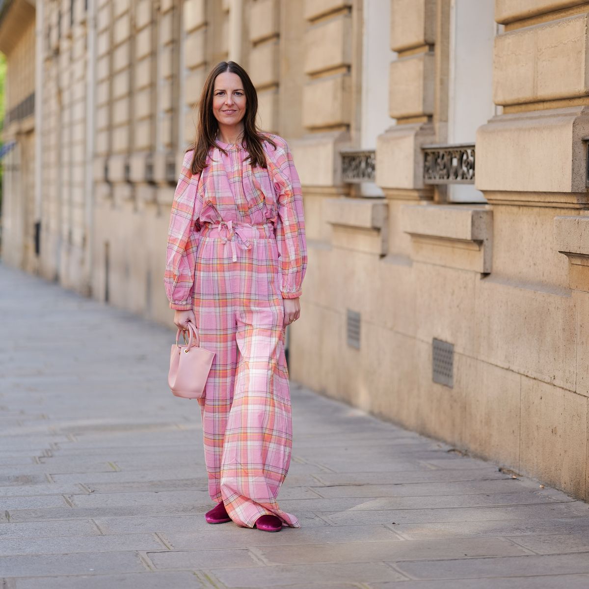 paris, france april 21 alba garavito torre wears gold earrings, a pale pink orange white checkered print pattern high neck puffy long sleeves shirt from the label edition, matching pale pink orange white checkered print pattern large wide legs pants from the label edition, a pale pink shiny leather handbag, gold rings, neon pink velvet loafers from babouches frulan, during a street style fashion photo session, on april 21, 2023 in paris, france photo by edward berthelotgetty images