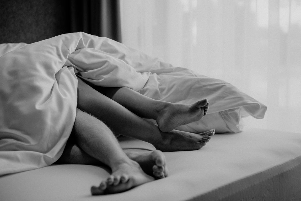 close up of feet of young couple in a bed, enjoying weekend together black and white photography
