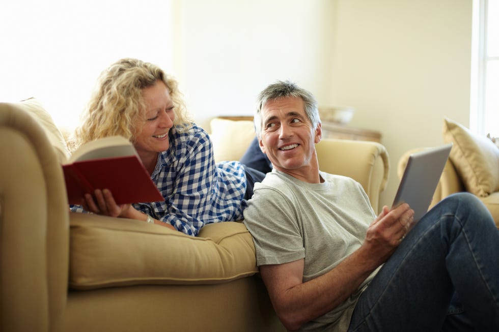 Couple on sofa with book and digital tablet