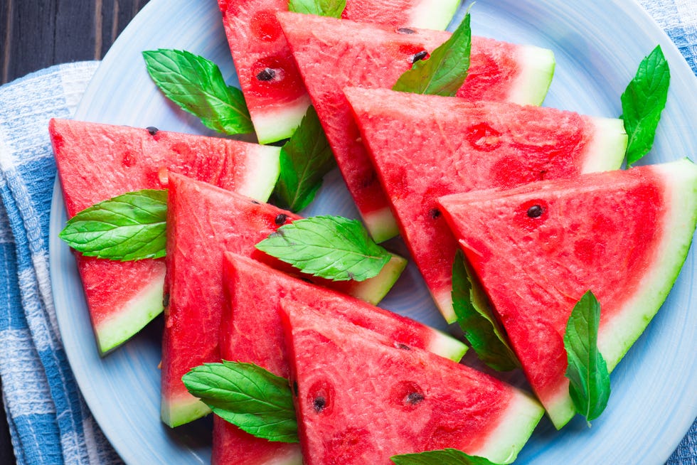 slices of watermelon with mint leaves on blue ceramic plate