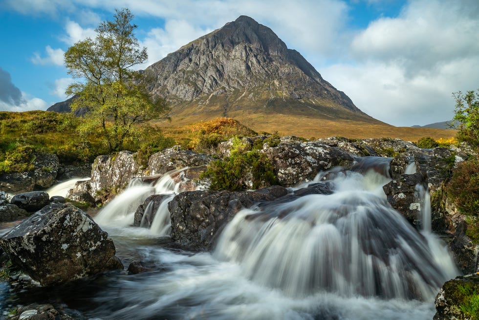 a waterfall with a mountain in the background