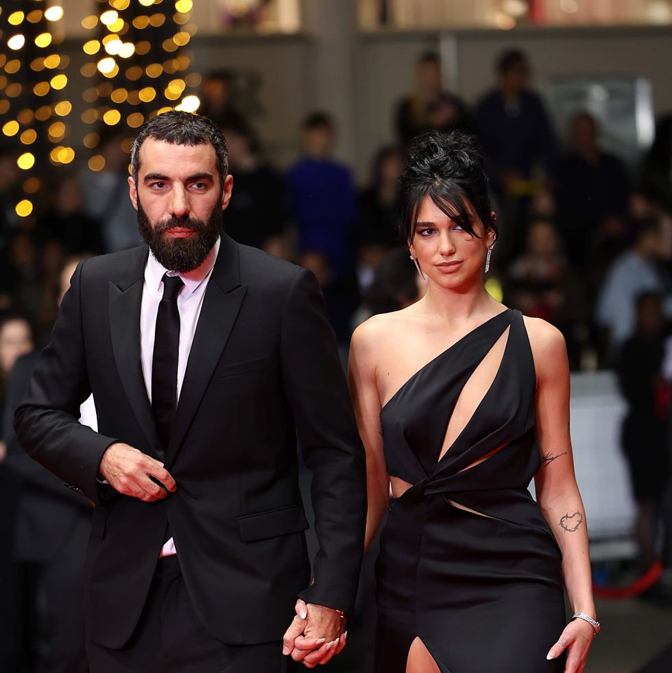 a man and woman walking on a red carpet