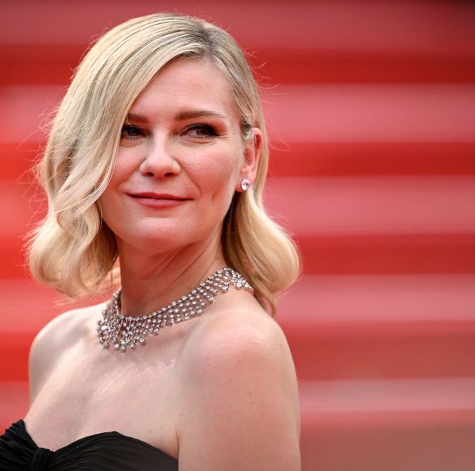 kirsten dunst on a red carpet in a black strapless dress