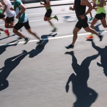Large Group Of People Running Fast In The City, Defocused Light And Shadows Sports Background abstract sports background unknown people running marathon distance real life, side view, ambient day light, copy space, blurred motion