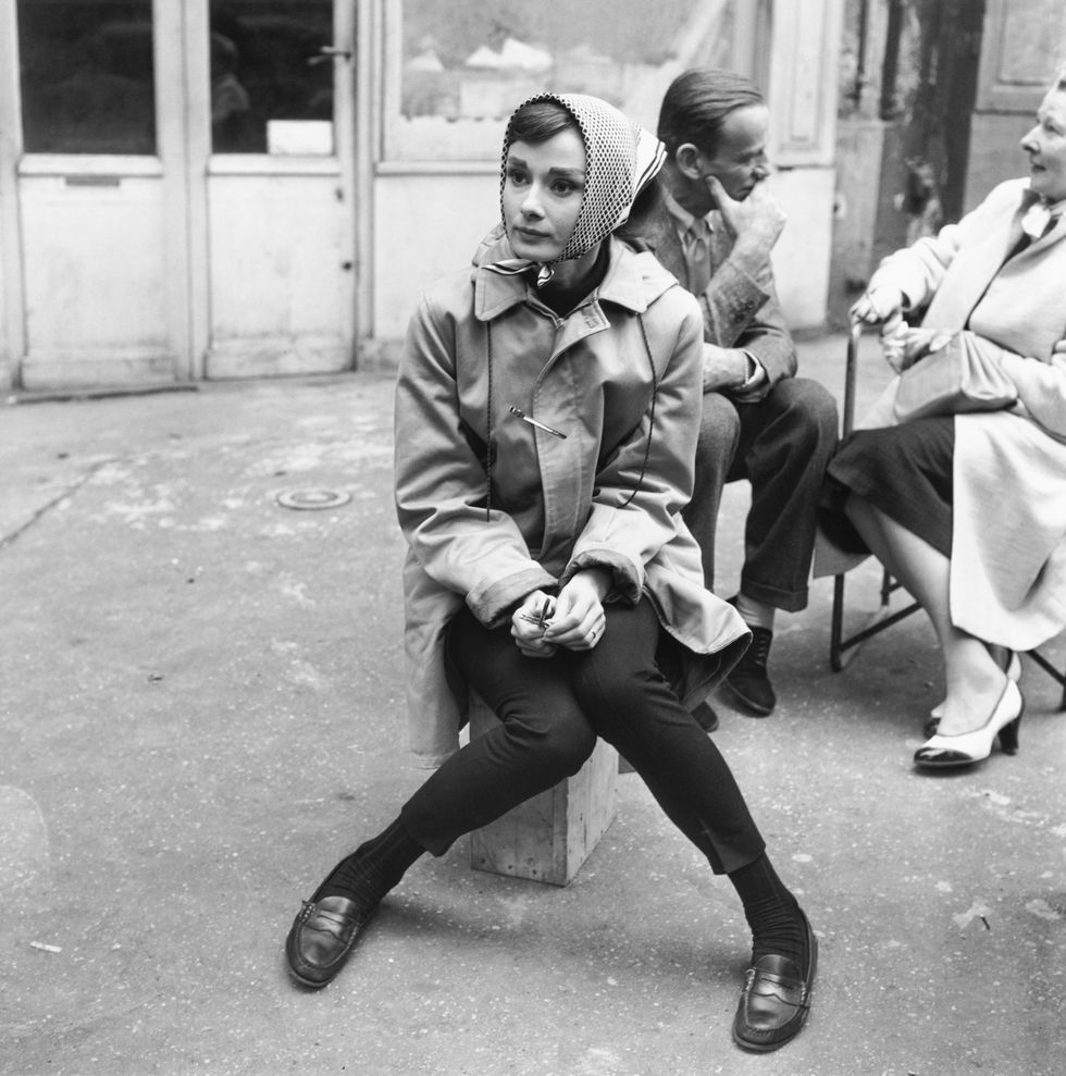 actress audrey hepburn 1929   1993 sitting on a crate near the eiffel tower in paris, during the filming of funny face, 1956 co star fred astaire 1899   1987 is behind her photo by paramount picturesgetty images