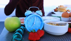 blue alarm clock with if intermittent fasting 16 and 8 diet rule and weight loss concept diet plan concept