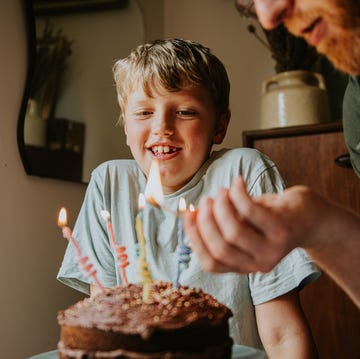 A father lights the birthday candles on his son's birthday cake birthday wishes for son