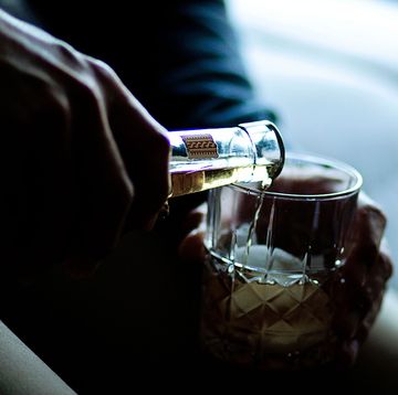 a person holding a glass of whisky