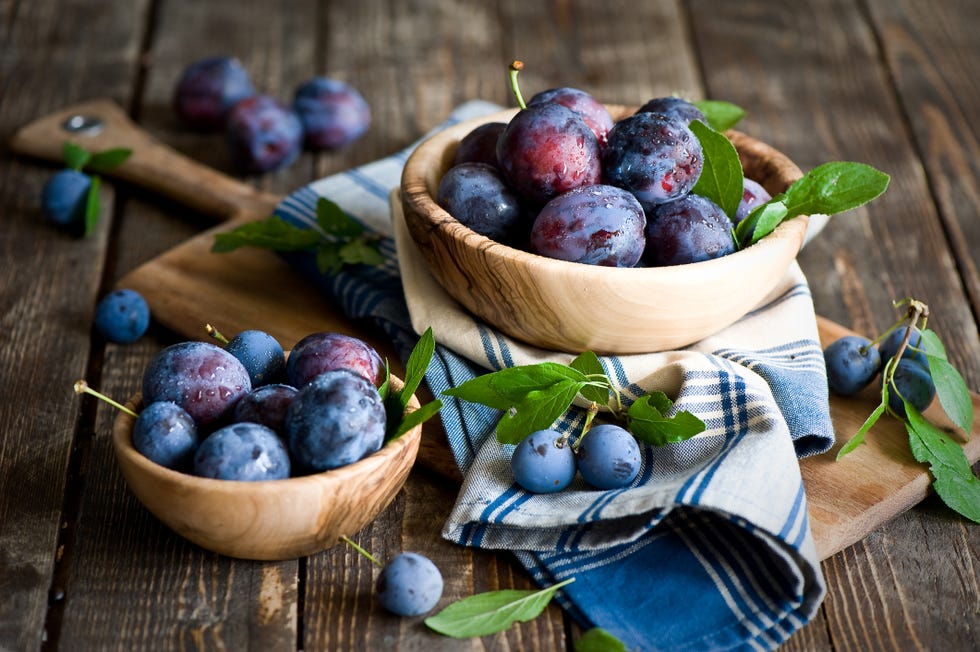 plums in wooden bowl with napkin
