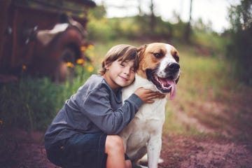 smiling toddler boy sitting with his dog