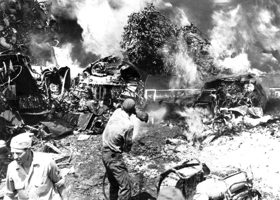 Amerikaans grondpersoneel richt brandslangen op het brandende wrak van een B24 nadat de bommenwerper in 1944 neerstortte op een vliegveld in ZuidItali