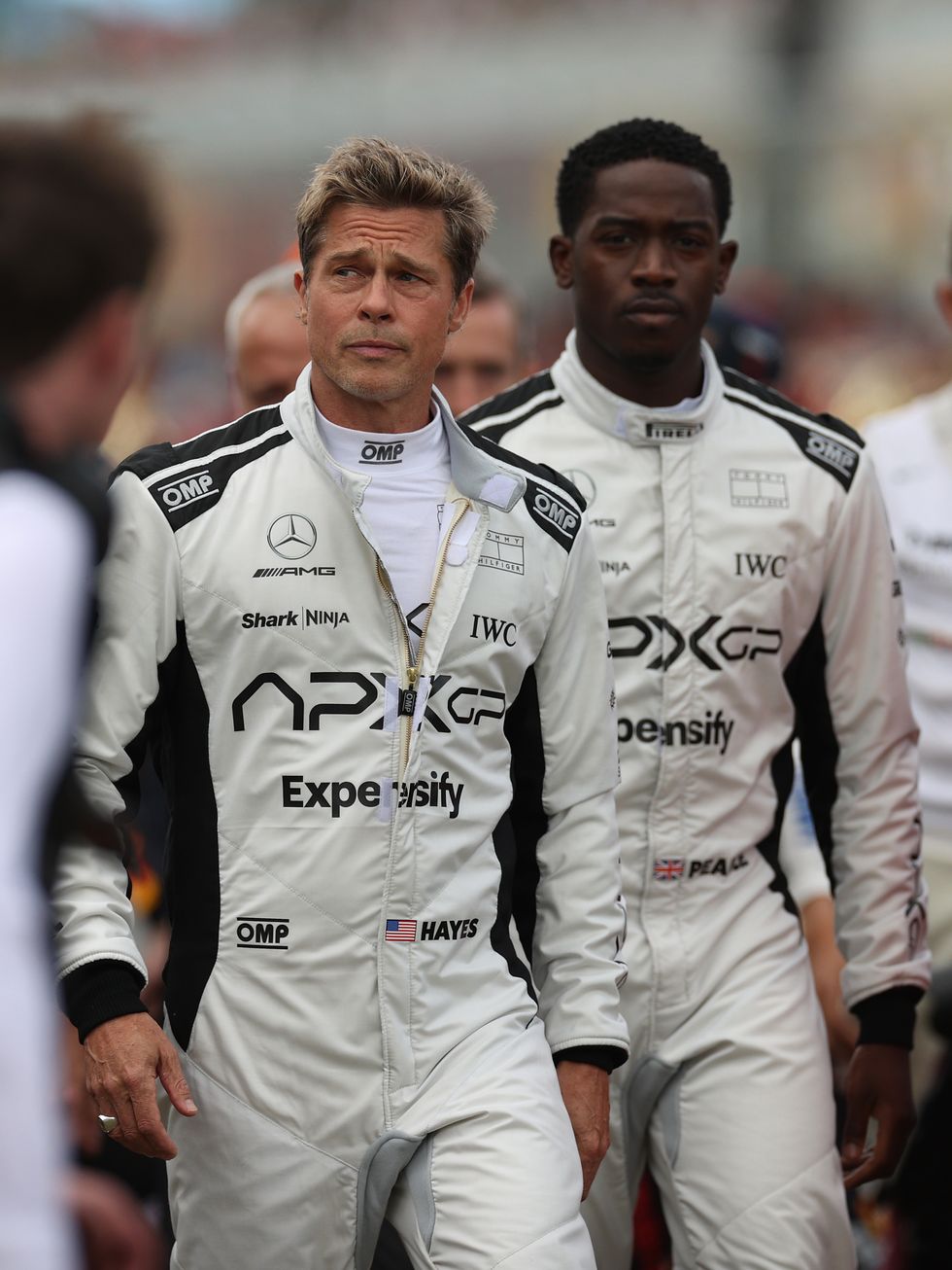 northampton, england july 09 brad pitt, star of the upcoming formula one based movie, apex, and damson idris, co star of the upcoming formula one based movie, apex, walk on the grid in front of carlos sainz of spain driving 55 the ferrari sf 23 on track during the f1 grand prix of great britain at silverstone circuit on july 09, 2023 in northampton, england photo by ryan piersegetty images