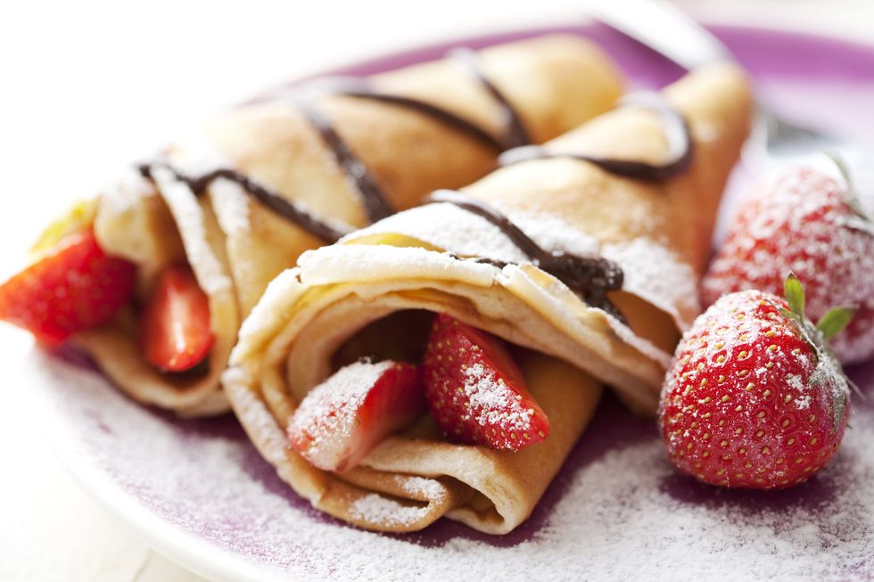 close up of two french style crepes, shallow dof some ingredients in the background