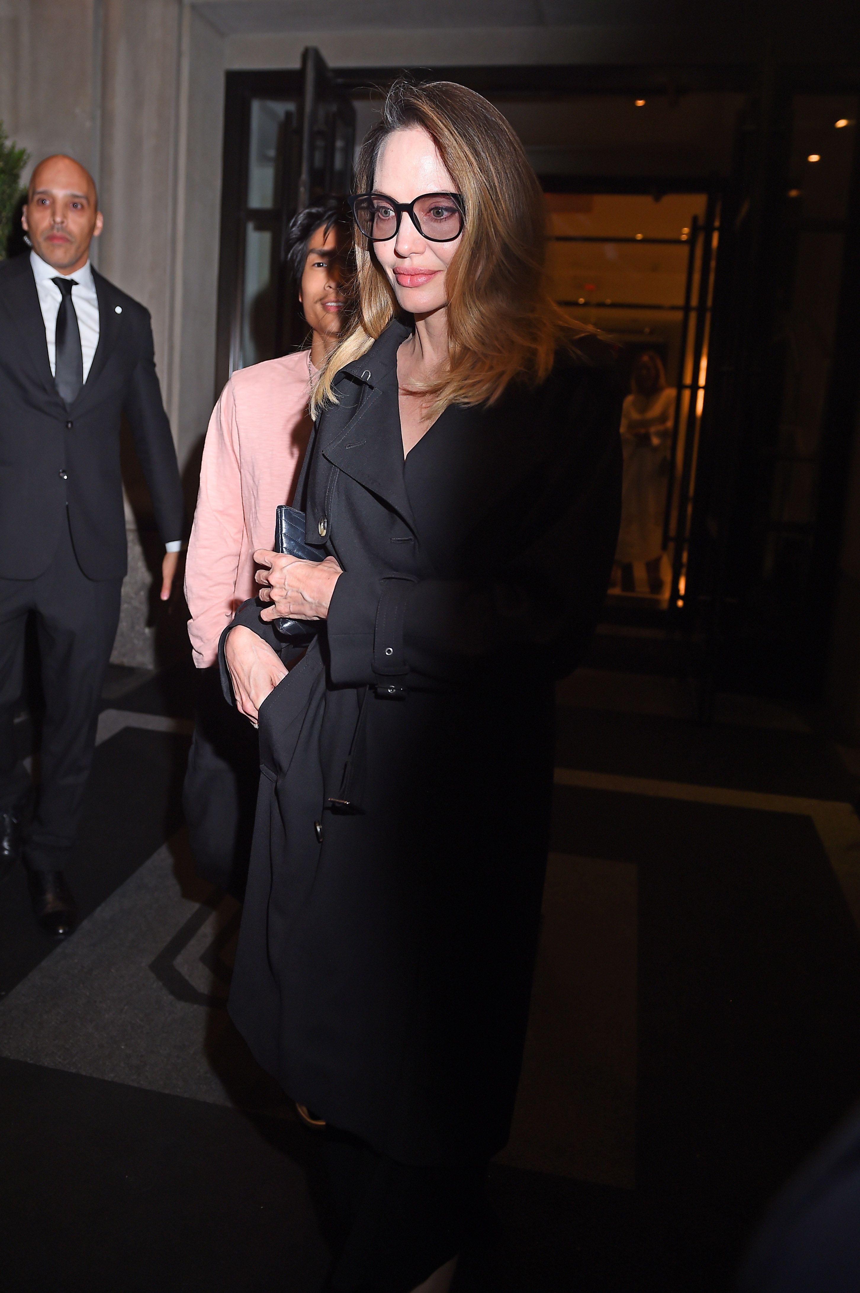Angelina Jolie in a Chic Long Black Overcoat and Carrying a Dior