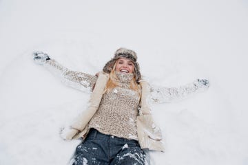 mid adult woman lying on snow