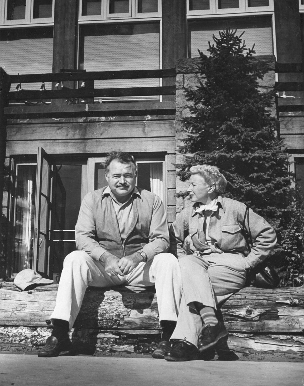 portrait of american author ernest hemingway 1899   1961 and his wife, journalist mary welsh hemingway 1908   1986, as they sit outside on a log fence while on vacation, 1946 photo by photoquestgetty images