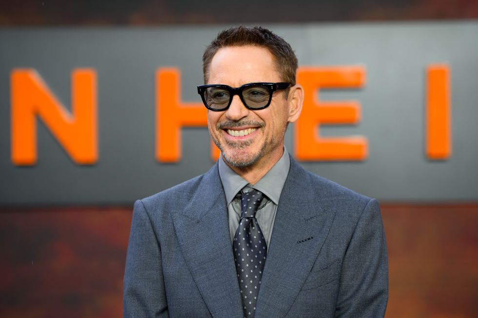 robert downey jr wearing tinted black glasses and a blue and grey suit with a polka dotted tie at the premiere of oppenheimer in 2023
