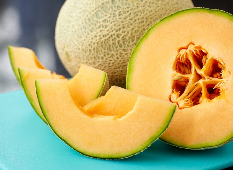 A close up of a sliced cantaloupe on a blue table