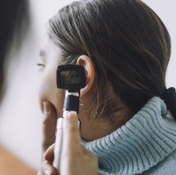 vrouw kijkt met otoscoop in het oor van een andere vrouw