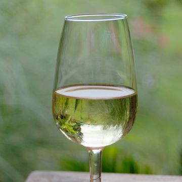 a glass of white wine on a wooden table