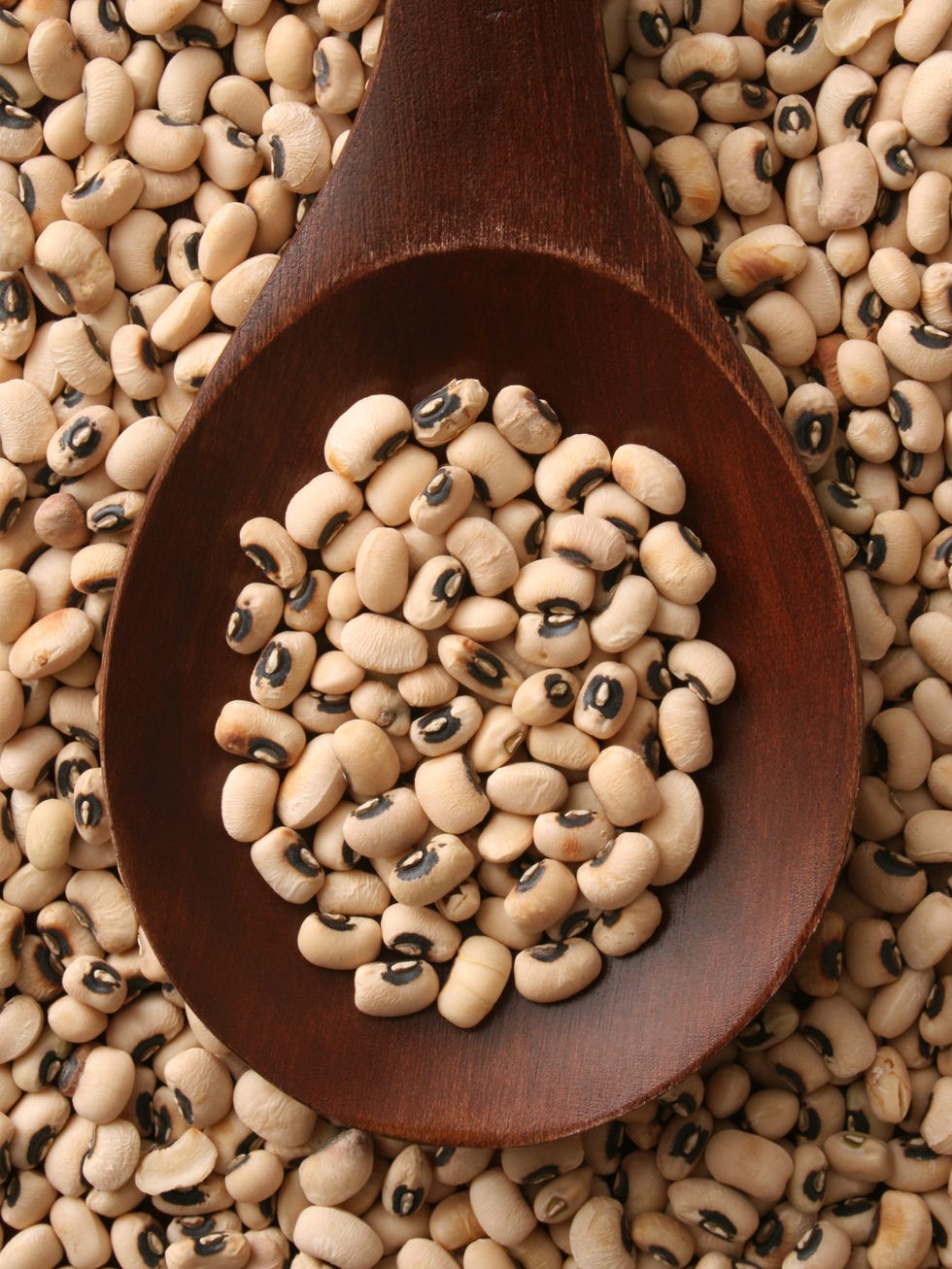 top view of wooden spoon full of black eyed peas
