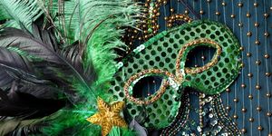 Mardi Gras mask on beaded green background.