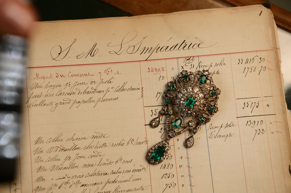 a picture taken on december 18, 2012 shows a corsage pin made of emeralds, diamonds, silver and gold, displayed on a 1867 page order of empress eugenie, the wife of napoleon iii, emperor of the french, in the mellerio jewelry store in paris founded in 1613, french jewelry house mellerio is the oldest family owned company in europe and has been making the fifa ballon dor trophy since 1956    afp photo  franck fife        photo credit should read franck fifeafp via getty images