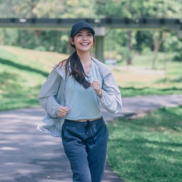 fashionable female runners dressed in modern gear, finds peace in rhythmic beats recharge energy in the midst of lifes steady, serene flow embrace tranquility while jogging through public parkway