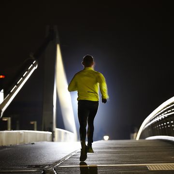 solo run on bridge, night time, rear view