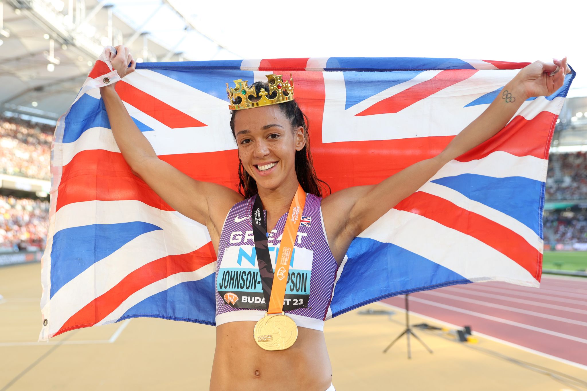 budapest, hungary august 20 katarina johnson thompson of team great britain celebrates with a crown and a great britain flag after winning gold in the womens 800m heptathlon final during day two of the world athletics championships budapest 2023 at national athletics centre on august 20, 2023 in budapest, hungary photo by michael steelegetty images