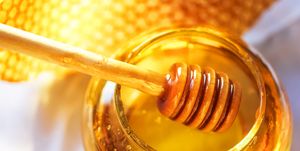 honey dipper on the bee honeycomb background honey tidbit in glass jar and honeycombs wax