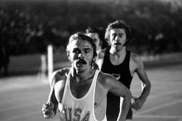 steve prefontaine wearing a usa vest and running ahead of other athletes on a track